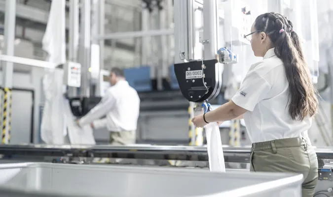 Operaria manipulando maquinaria.